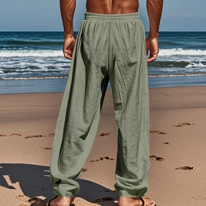 Dettaglio dei pantaloni larghi in lino da uomo verde oliva con elastico in vita in spiaggia