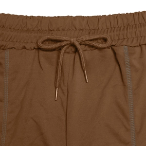 Detail of brown sportswear shorts with elastic waist and metal-tipped drawstring cords