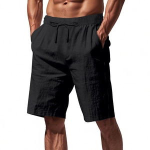 Detail of black linen beach shorts featuring elastic drawstring waist and textured fabric
