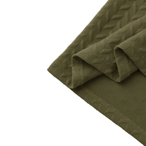 Detailed close-up of army green jacquard polo shirt fabric with textured herringbone pattern