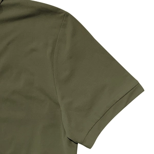 Detailed close-up of army green polo shirt sleeve featuring durable double-stitch hem