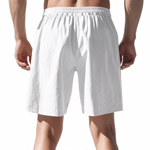 Detail view of the elastic waistband on men's white linen beach shorts from behind