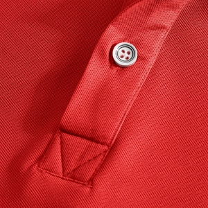 Macro shot of bright red polo shirt showing honeycomb pique fabric and white button detail