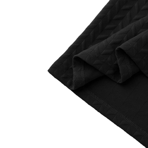 Detail of premium black polo shirt fabric featuring heavy jacquard herringbone texture
