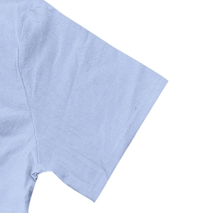 Detail of light blue linen shirt sleeve showing clean stitching and fabric texture
