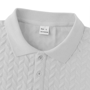 Detail of white textured polo shirt showing the collar, buttons, and 100% polyester label