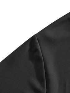 Gros plan sur la texture respirante du tissu piqué noir et la couture de l'épaule du polo