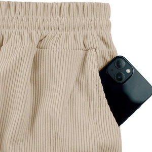 Detailed close-up of beige corduroy shorts featuring elastic waistband and side pockets