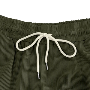 Detail of dark green corduroy shorts with elastic waistband and white metal-tipped drawstrings