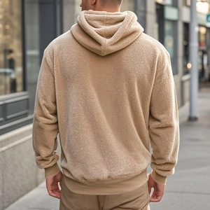 Detail of camel Sherpa fleece texture on men's oversized hooded sweatshirt with ribbed cuffs