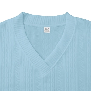 Détail du haut en tricot bleu clair à col en V avec étiquette tissée et texture jacquard