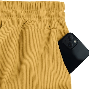 Detail of ginger yellow corduroy shorts featuring elastic waist and deep side pockets