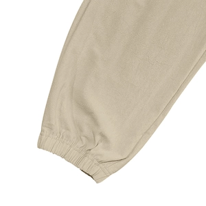 Macrodetail van elastische geribbelde manchetten op beige linnen broek met fijn stiksel