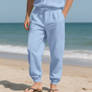 Detail of light blue men's linen beach trousers with drawstring waist and elastic cuffs