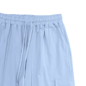 Detail view of baby blue linen pants with elastic drawstring waist and side pockets