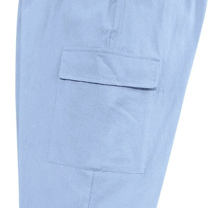 Detail van de cargo-zak op een lichtblauwe linnen broek met natuurlijke textuur