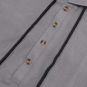 Close-up of gray linen shirt fabric with faux tortoise buttons and black trim detail