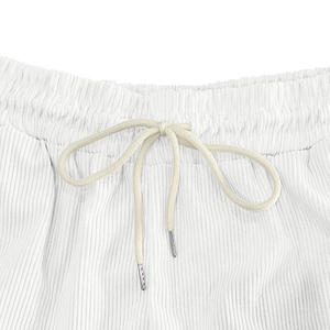 Detail of white corduroy shorts with elastic drawstring waist and metal aglets