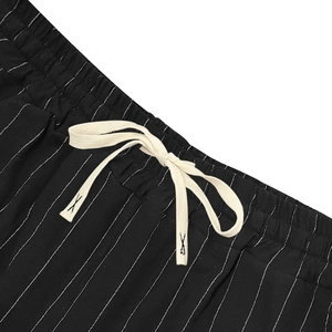 Detail of elastic waistband with cream drawstring on black striped linen shorts