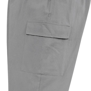 Detailed close-up of grey linen cargo pants showing functional flap pocket and durable stitching