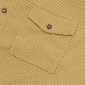 Dettaglio della tasca di camicia in velluto a coste con patta a punta e bottone scuro