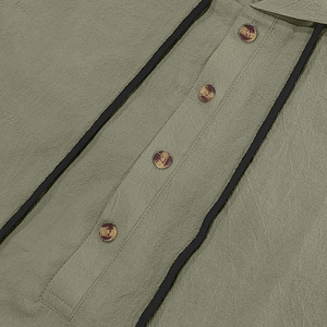 Close-up of linen shirt fabric texture with amber buttons and black striped details