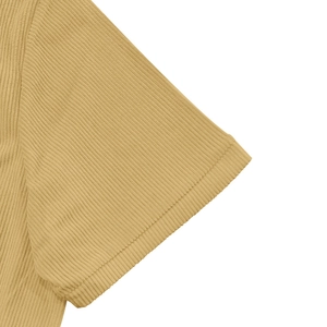 Dettaglio della manica di camicia giallo senape che mostra la trama a coste del velluto