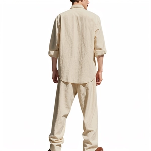 Vista posteriore del set in lino beige da uomo con camicia ampia e pantaloni lunghi