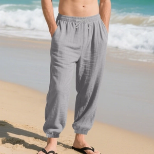 Men's grey casual linen beach trousers with drawstring waist and elastic ankles on the beach