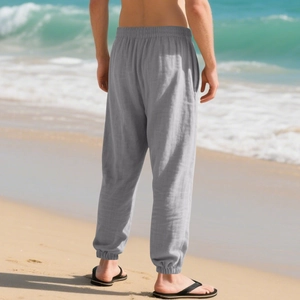 Men's casual linen trousers in grey with elastic waist and jogger cuffs at the beach