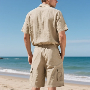 Khaki Leinen-Set für Herren mit Hemd und Shorts sowie großen Cargo-Taschen am Strand-Hintergrund