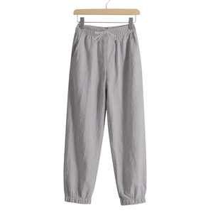 Detail of light grey linen jogger pants featuring drawstring waist and elastic cuffs