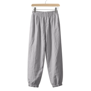 Detail of light grey linen jogger pants featuring elastic waist and tapered ankle cuffs