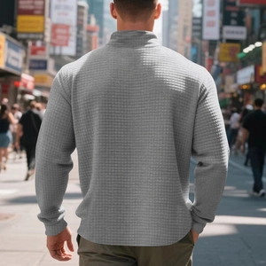 Macro detail of men's grey waffle knit sweater with a sleek stand collar and half-zip design