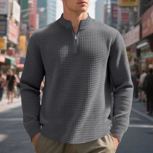 Macro detail of men's quarter-zip sweatshirt showing grey waffle knit texture and stand collar