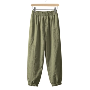 Detail of olive green linen jogger pants featuring elastic waist and tapered cuffs