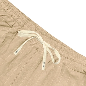 Detail of khaki linen shorts waistband with elastic waist and white braided drawstring