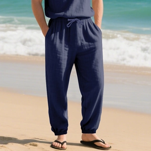 Detail of navy linen beach pants with elastic drawstring waist and cuffed hem on sunny beach
