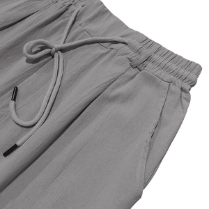 Detail of grey linen pants featuring elastic waistband with adjustable drawstring and side pockets