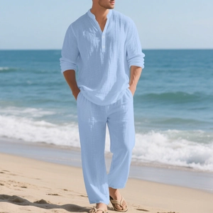 Detail van lichtblauwe linnen herenshirt en broekset met ademende stoftextuur aan zee