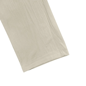 Detailed macro view of the trouser leg hem showing linen fabric texture and neat stitching
