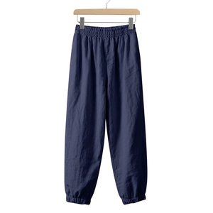Detail of navy blue linen jogger pants with elastic waist and cuffed ankles for casual wear