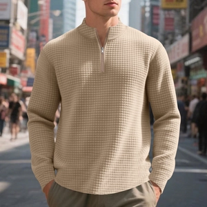 Close-up of the waffle texture and metal quarter-zip on this warm beige men's sweatshirt