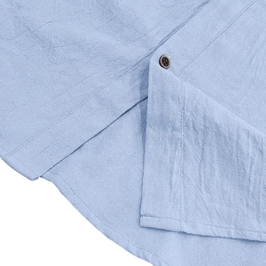 Detail of light blue linen shirt featuring vintage brown button and natural fabric texture