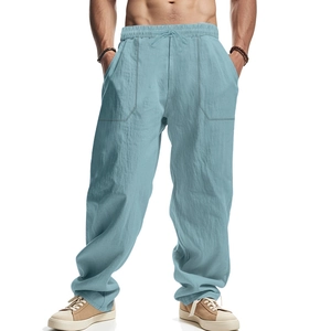 Detail view of light blue linen trousers showing elastic drawstring waist and fabric texture