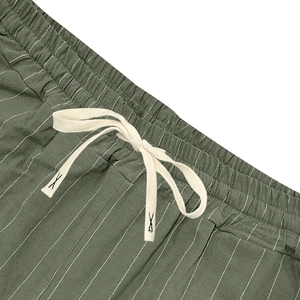 Detailed macro view of elastic waistband with drawstring on green striped linen shorts