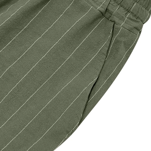 Detail of dark green linen shorts with vertical white stripes and elastic waistband