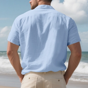 Rear view of a light blue linen short-sleeve shirt for men on a sunny summer beach