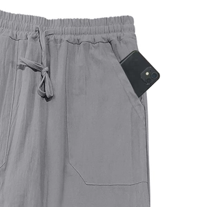 Detail view of deep side pockets on gray linen pants with a phone showing utility