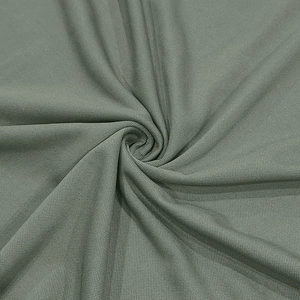 Gros plan du tissu de polo piqué vert olive montrant une texture de maille respirante